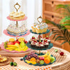 A three-tier plastic dessert stand displaying cupcakes and muffins on a wooden table.