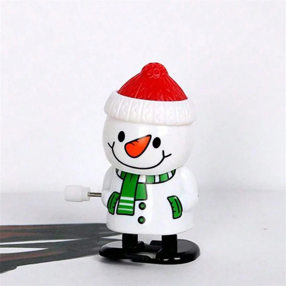 A white snowman figurine wearing a red Santa hat and a green scarf, displayed on a black base.