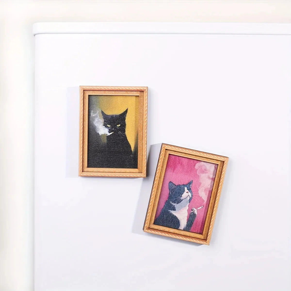 Two framed artwork prints featuring black and gray cats on white backgrounds
