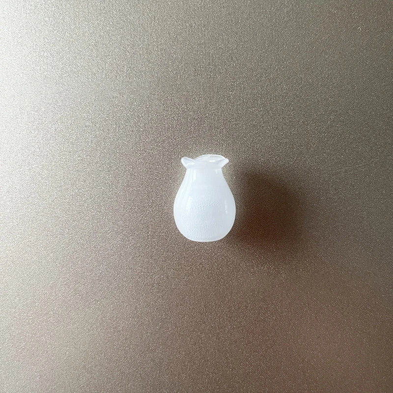 A clear, smooth glass fridge magnet shaped like a small, rounded vessel.