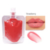 A small bottle of strawberry lip oil gloss next to a close-up of the product on lips.