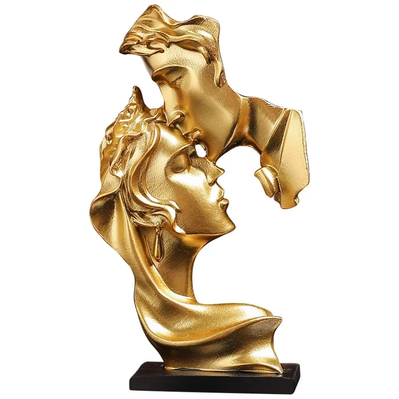 Statue en résine dorée représentant deux silhouettes féminines s'étreignant.
