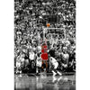Black and white photo of a basketball game featuring players and fans during a slam dunk.