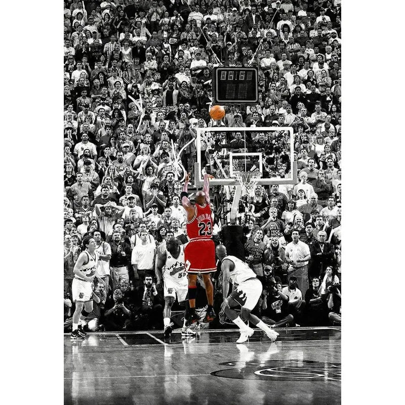 Black and white photo of a basketball game featuring players and fans during a slam dunk.