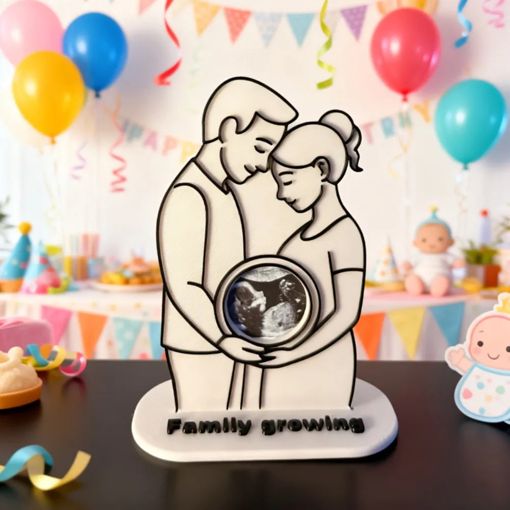 A white silhouette art piece depicting a mother and baby embracing, with the text Family Growing underneath.