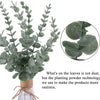 A bundle of artificial eucalyptus leaves in various shades of green displayed in a glass vase.