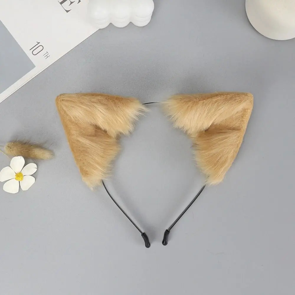 A pair of tan plush fox ears headband with black straps displayed on a gray surface.