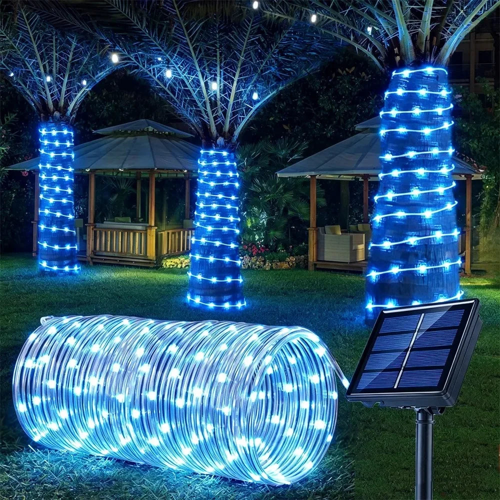 A long, cylindrical rope light made of blue LED strands is displayed outdoors on grass.