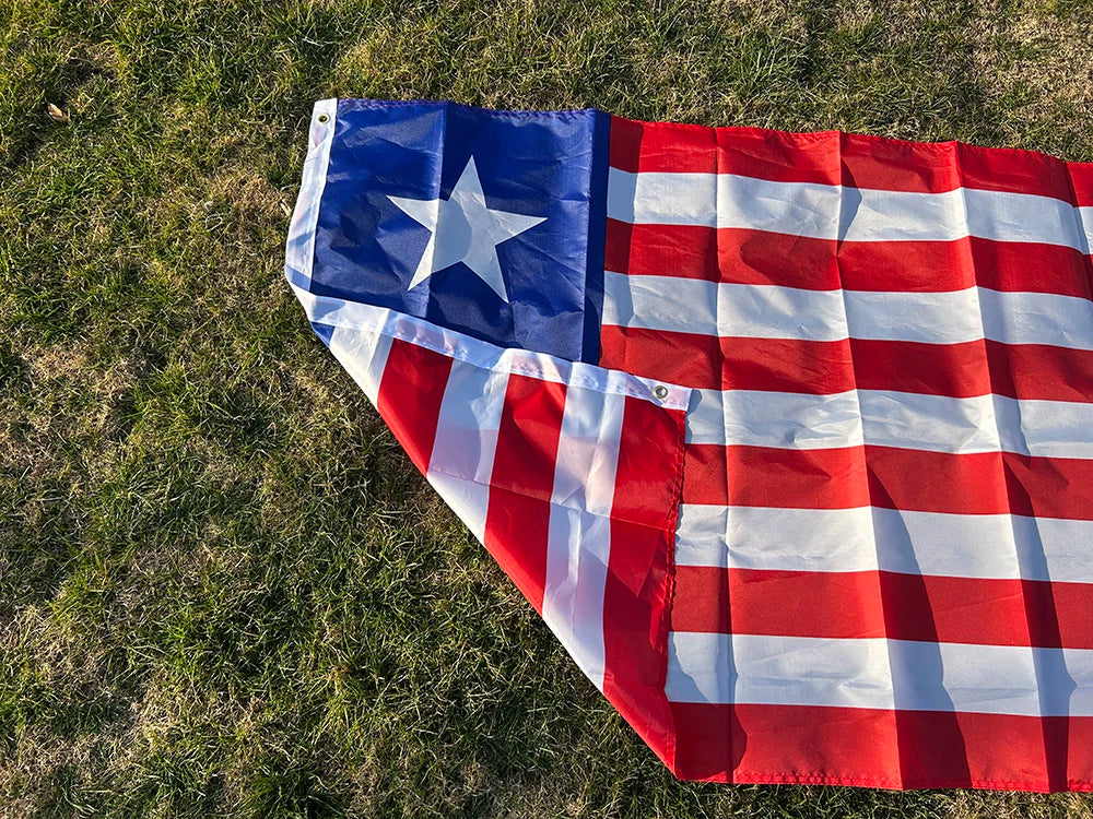 A decorative banner displaying the flag of Liberia, featuring blue, white, and red stripes and a white star on a green lawn.
