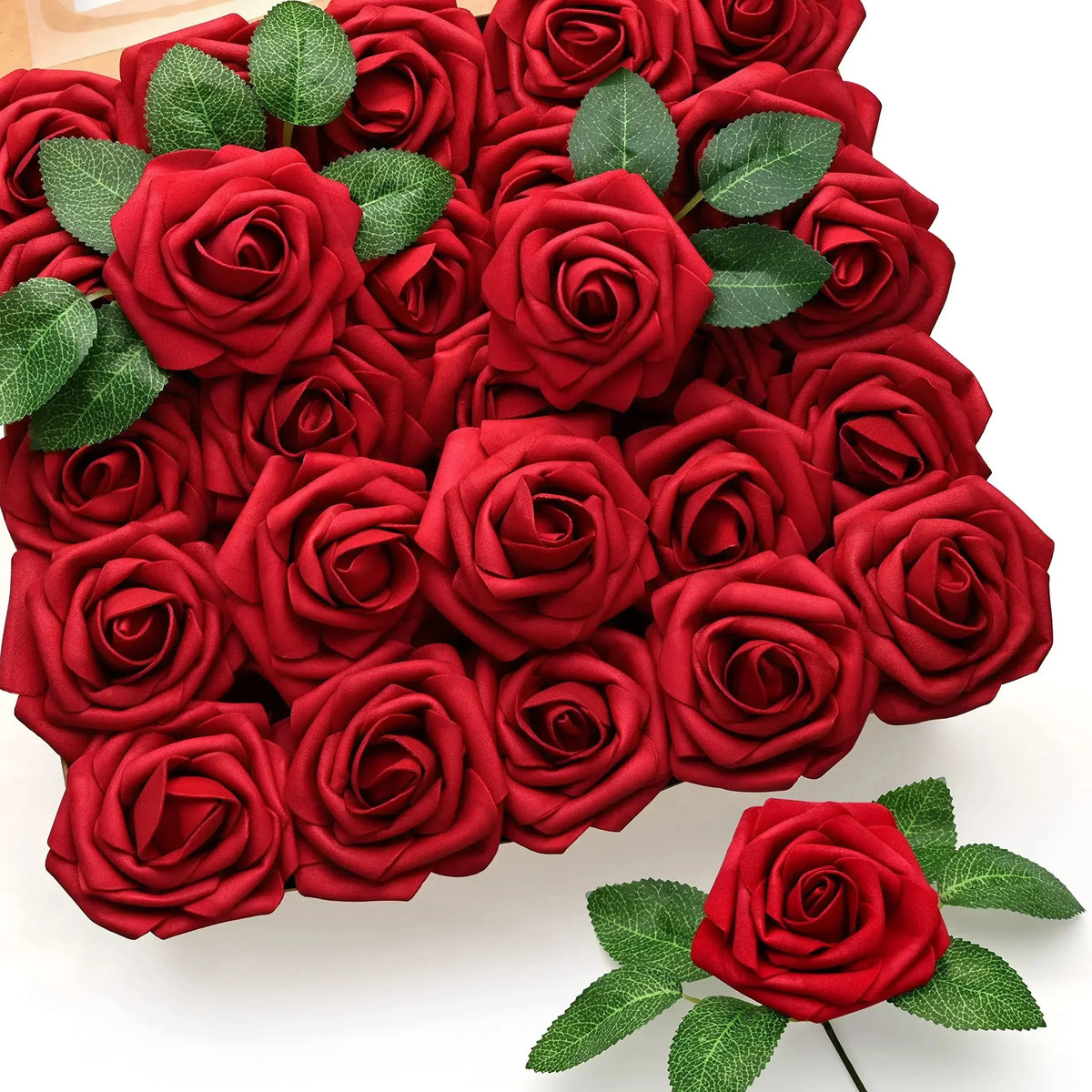 A dense bouquet of deep red lifelike foam roses with green leaves.
