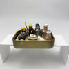 A hand-painted mini nativity set featuring figures of animals and people stored in a gold tin box.