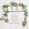 A silk wisteria vine garland draped over a wooden trellis for wedding or home decor.