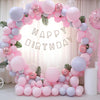 A balloon arch decoration featuring pastel pink and purple balloons for a birthday party backdrop.