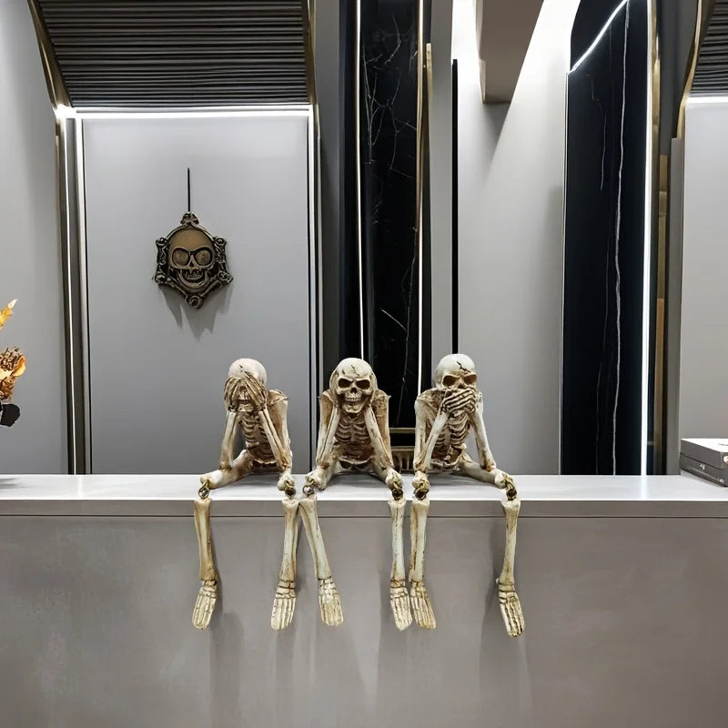 A set of realistic Halloween skeleton resin statues displayed on a modern counter.