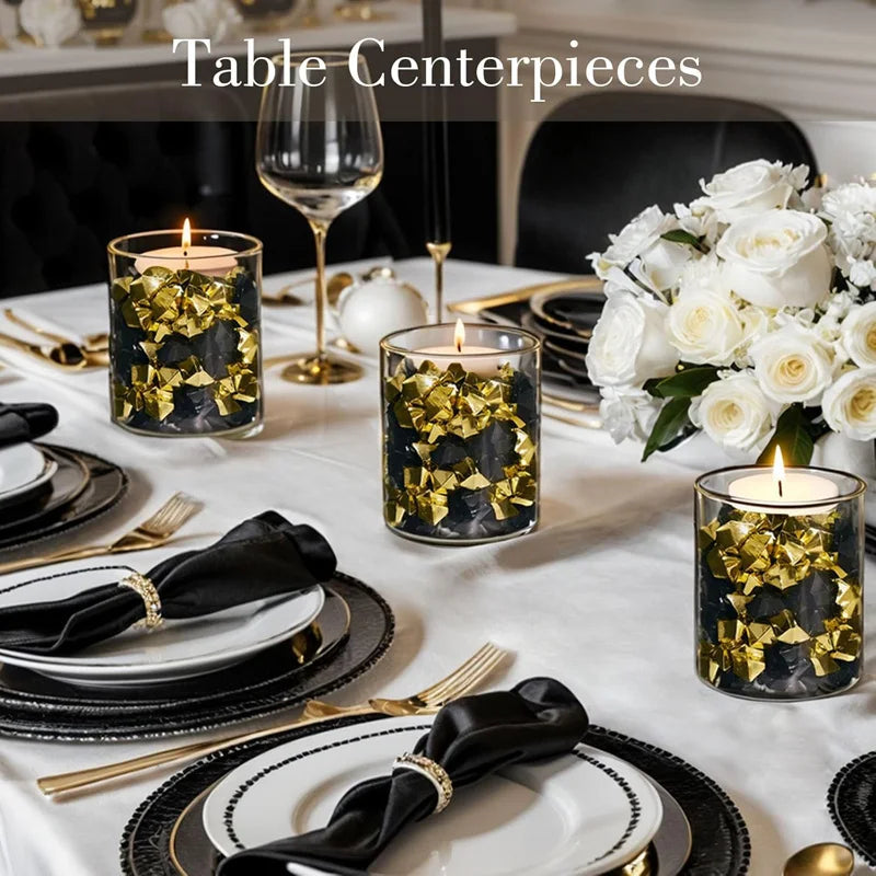 Table centerpieces featuring gold crushed diamond acrylic pebbles in dark glass candle holders.