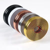 A stack of self-adhesive PVC edge guard strips in various colors including black, white, copper, silver, and gold.