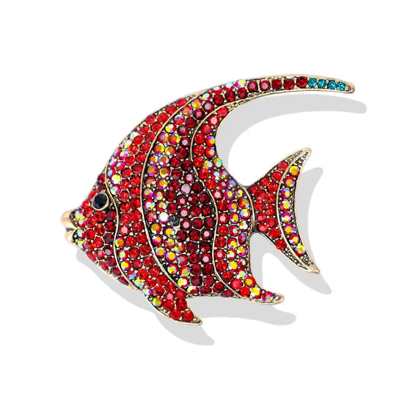 A vintage marine life brooch pin set featuring a colorful, detailed fish design encrusted with various gemstones.