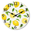 A round wall clock face featuring yellow lemons and green leaves as decorative elements.