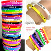 A variety of silicone bracelets featuring the name Jesus with a heart design in multiple colors stacked and displayed on a wr