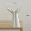 A white ceramic hand sculpture with open fingers, used as a vase or home décor item.