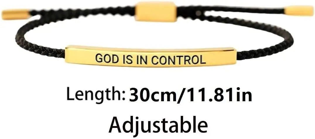 A gold-colored stainless steel bracelet with black cord and the text GOD IS IN CONTROL engraved on a bar.