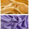 Two swatches of satin fabric in gold and purple colors showing the drape and sheen.