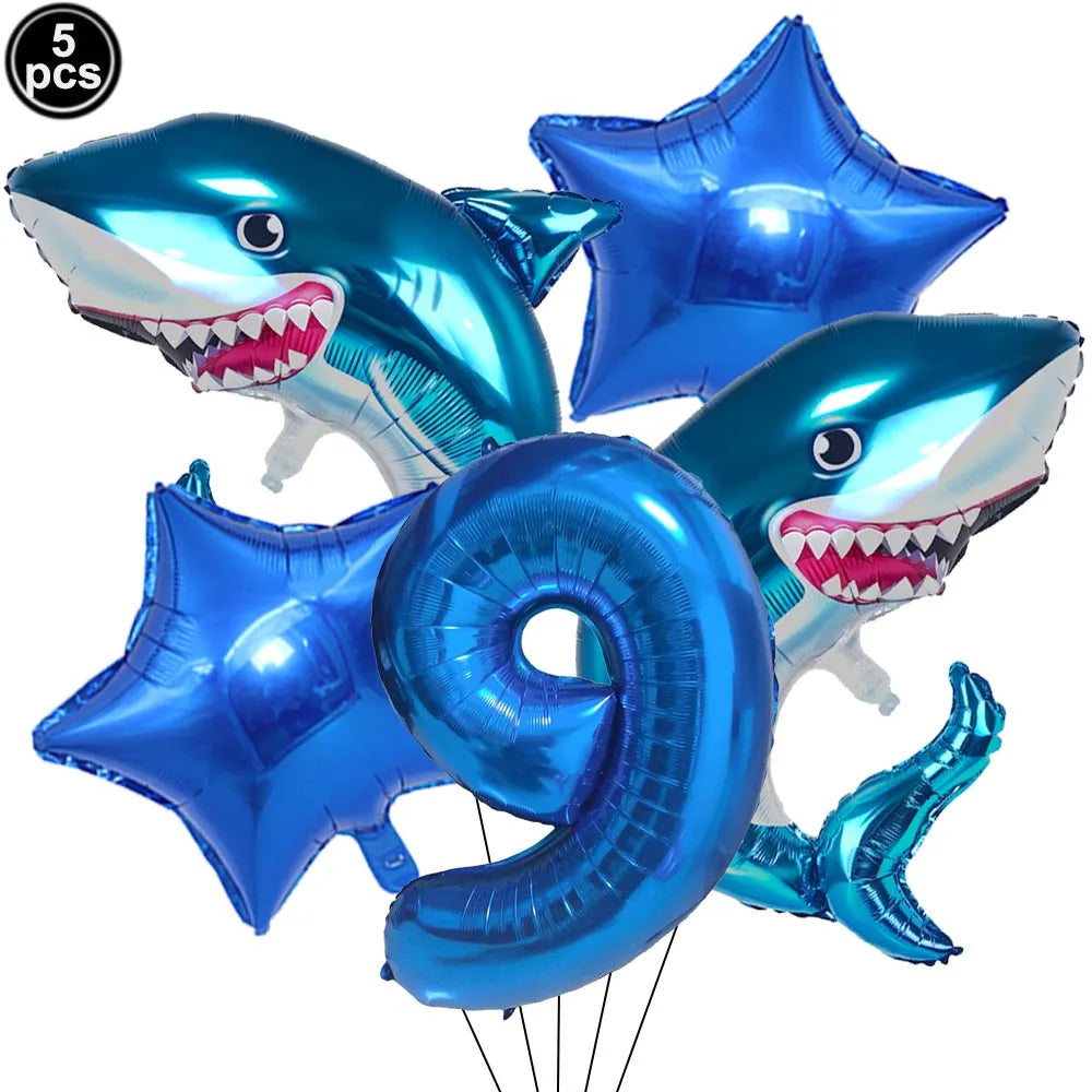 A set of blue shark foil balloons and a blue number nine balloon for an ocean-themed party decoration