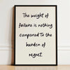 A framed black and white motivational quote print on a light background with handwritten text.