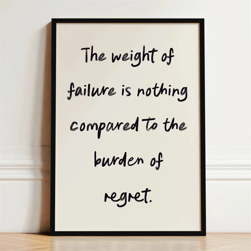 A framed black and white motivational quote print on a light background with handwritten text.