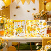 Yellow and white bee honey gift bags with handles for party favors displayed on a table.