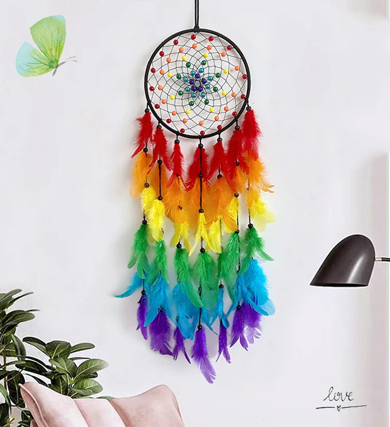 A colorful feather dream catcher with a black hoop and dangling feathers is displayed on a white wall.