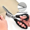 A pair of stainless steel pinking scissors with a serrated blade being held by a hand.