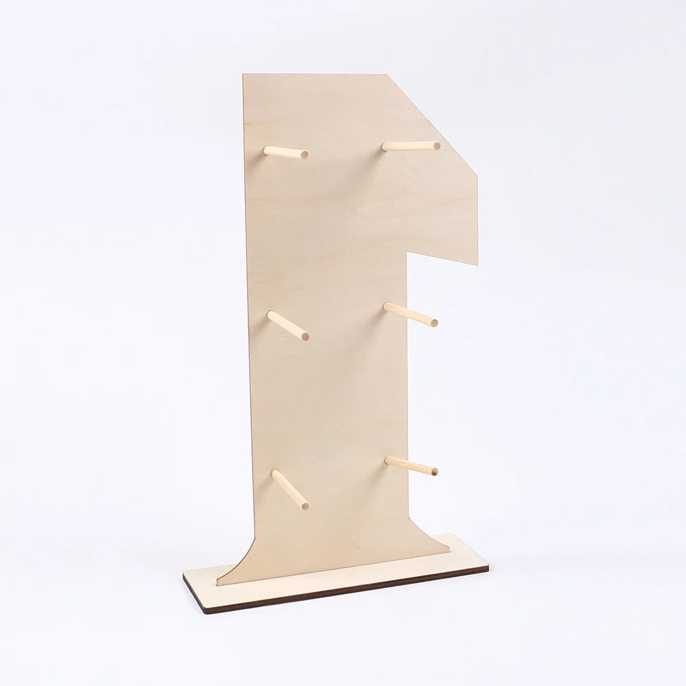 A tall, light wood display stand with a large number cutout and small wooden pegs for hanging items.