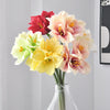A bouquet of artificial Clivia Amaryllis flowers in shades of yellow, peach, and deep red.