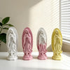A set of four resin statues depicting Our Lady of Guadalupe in white, pink, mauve, and yellow.