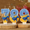 Three birthday candles shaped like the number 789 featuring blue dinosaurs on an orange background