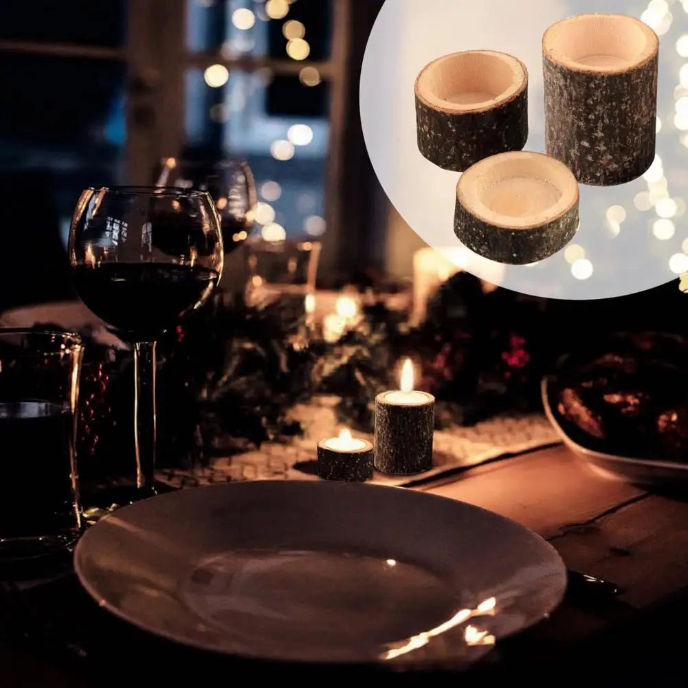 A rustic wooden stump candle holders set with candles and a glass of red wine on a dark table.