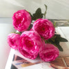 A bouquet of vibrant pink silk rose and peony artificial flowers displayed on a white surface.