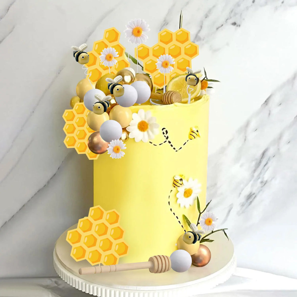 A yellow cake decorated with honeycomb shapes, small bees, and a honey jar on a white stand.