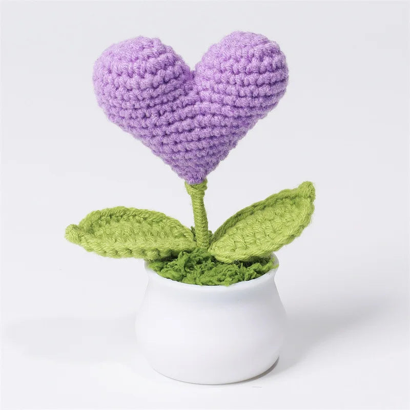 Hand woven purple heart flower in a green leaf potted in a white ceramic vase