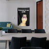 A black flag with white text welcoming to a crib featuring a yellow animal face.
