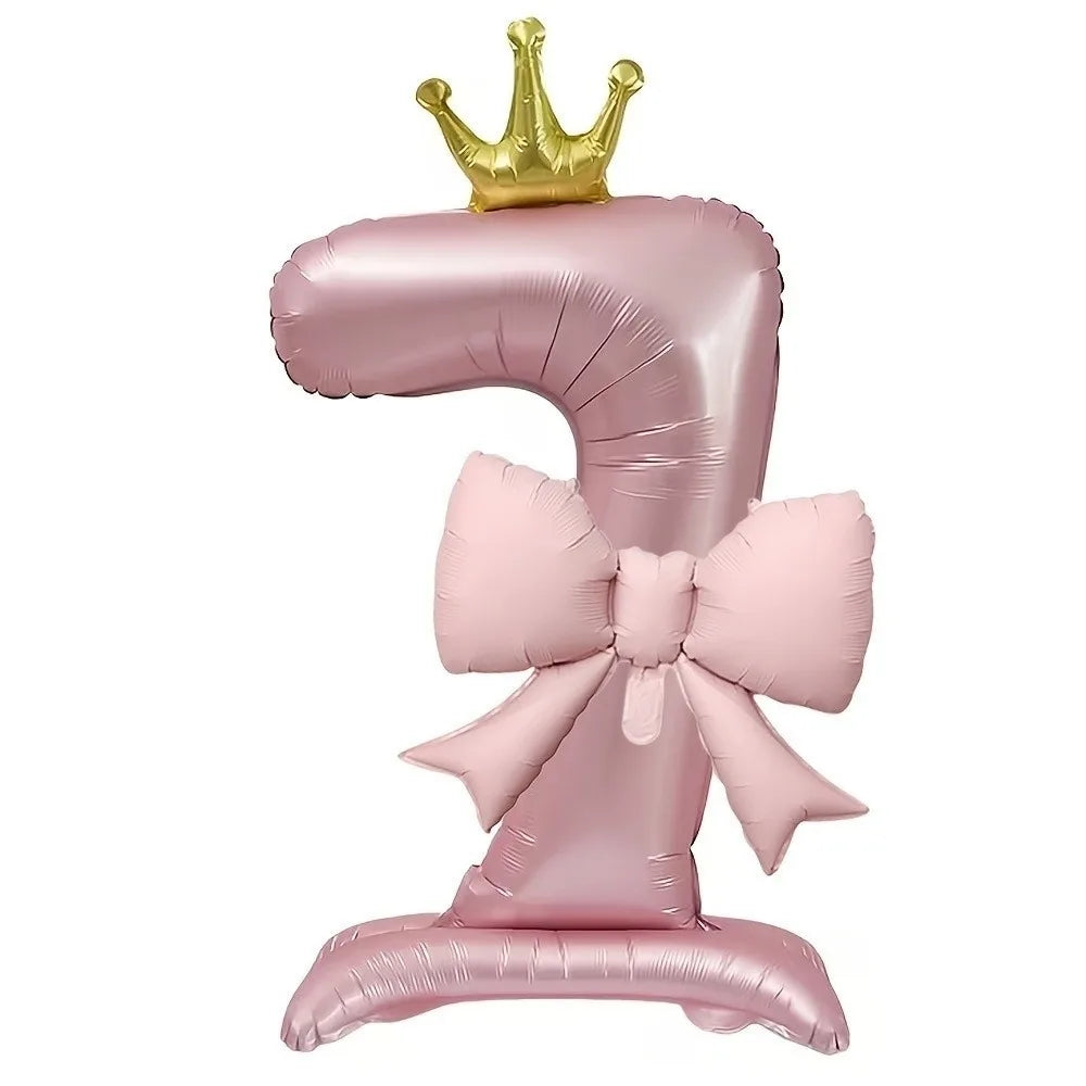A pink foil balloon shaped like the number 1, topped with a gold crown.