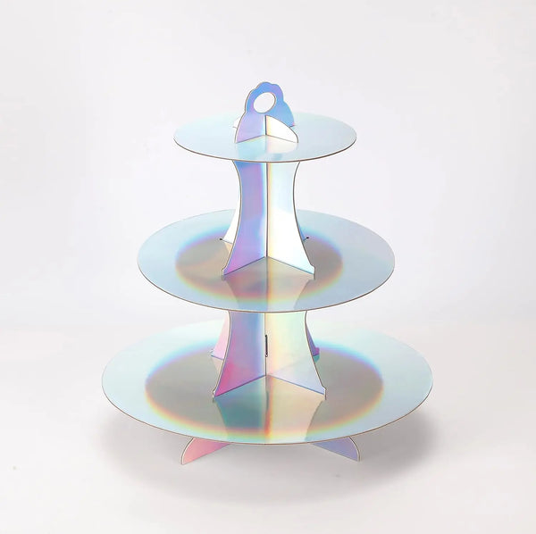 A three-tier rainbow colored cupcake stand with iridescent plastic cups for dessert displays.