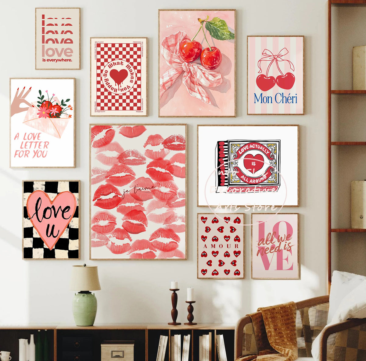 A gallery wall display featuring pink and red floral art prints with hearts and bows on a white wall.