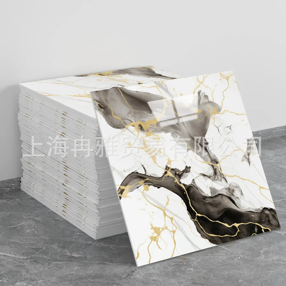 A stack of faux marble 3D self-adhesive wall tiles in gold and black marble pattern on a gray surface.
