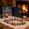 A box of a 24-Day Christmas Advent Calendar featuring Highland cow figurines displayed on a fluffy white rug.