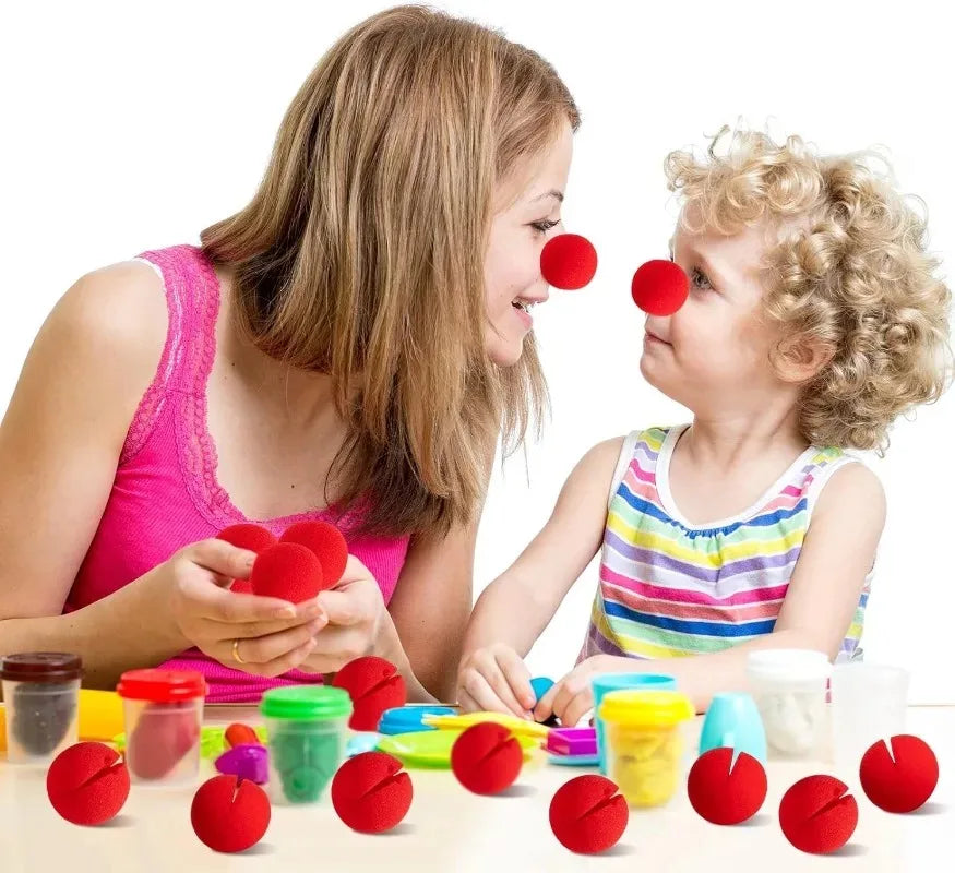 A child and an adult are playing with red foam balls, likely for costume noses or party props.