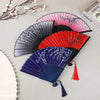 A collection of elegant vintage Chinese folding hand fans in various colors including black, pink, red, and blue, displayed o