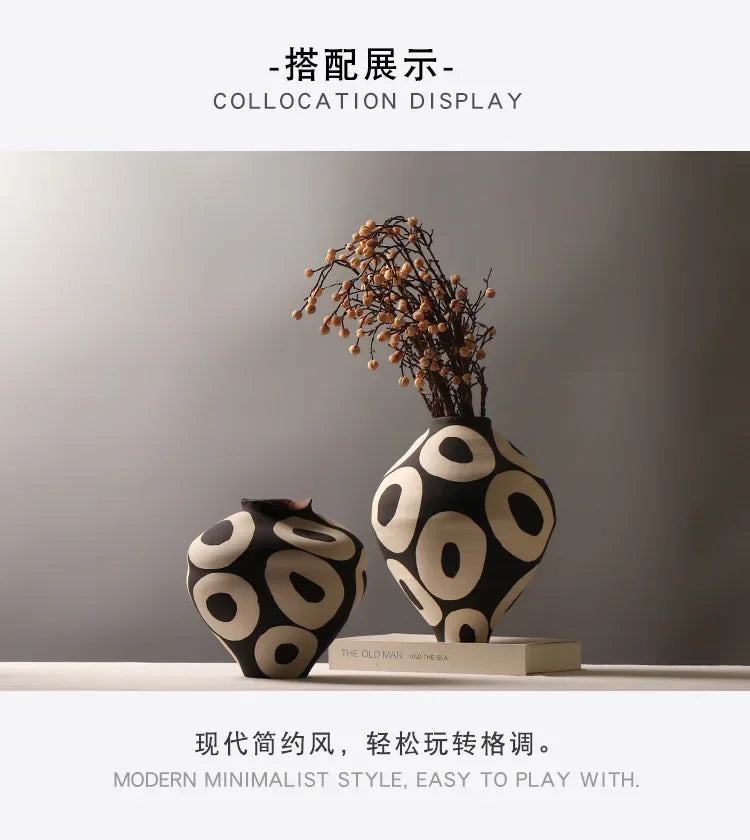 A black and white ceramic vase with a geometric circle pattern displayed on a light surface.
