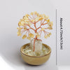 A natural crystal money tree with rose quartz base featuring delicate branches and amber-colored crystals.